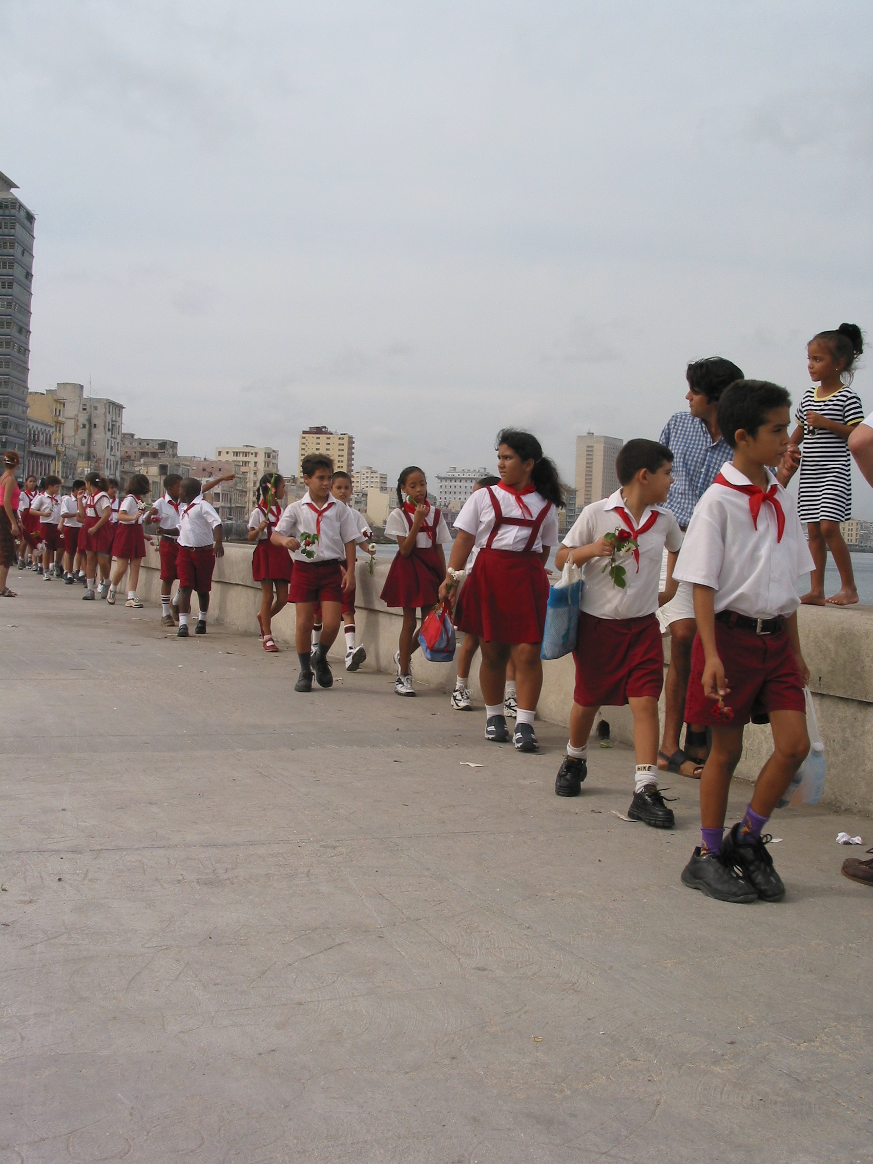 Students throw flowers into the sea